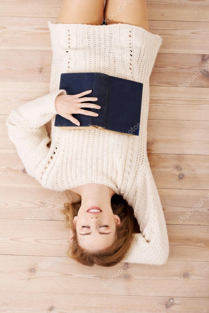 Relaxed young student woman lying on the floor