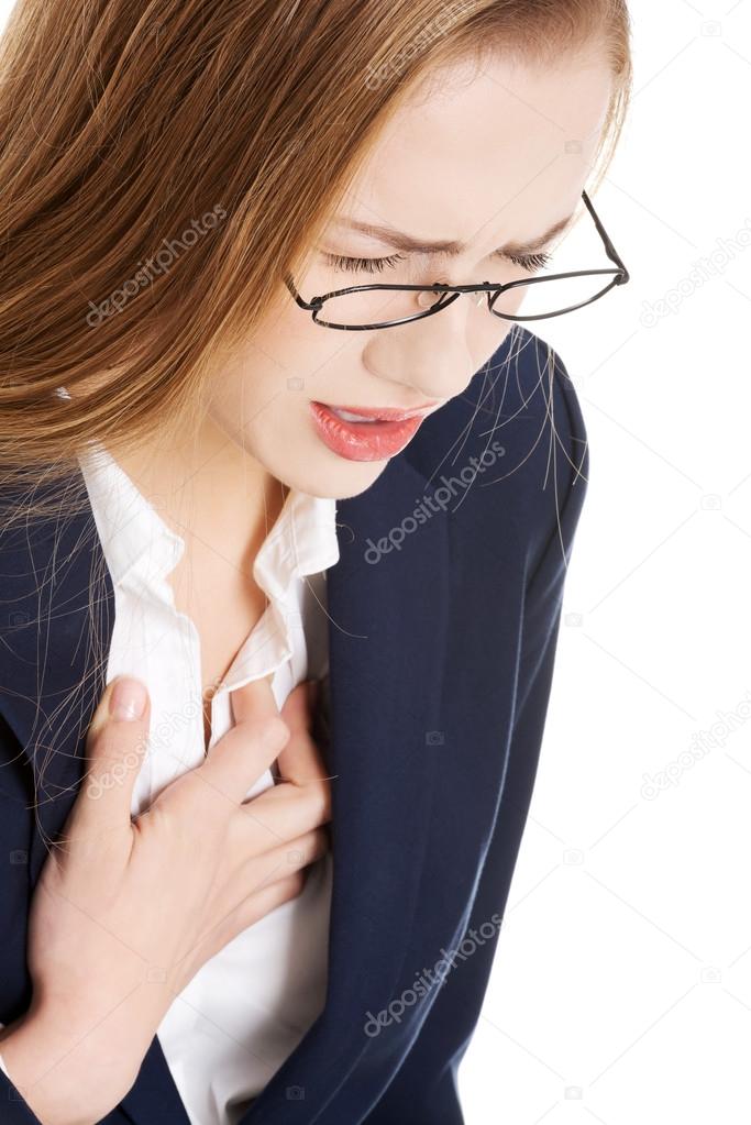Beautiful business woman touching her chest, feeling unwell.