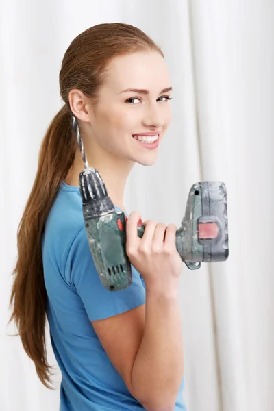 Lässige schöne Hausfrau hält Drill. — Stockfoto