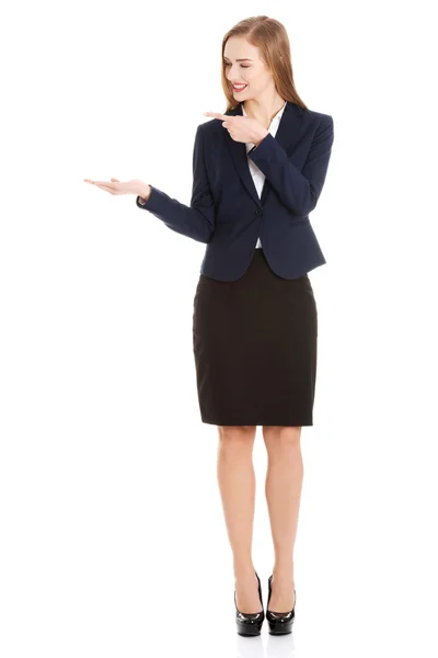 Beautiful caucasian business woman pointing on copy space on her side — Stock Photo, Image