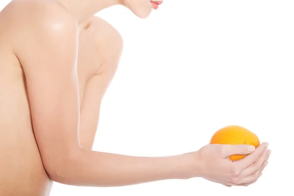 Beautiful topless woman holding an orange. — Stock Photo, Image