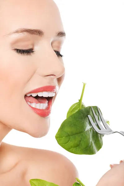 Hermosa mujer caucásica comiendo luttce verde fresco de un tazón — Foto de Stock