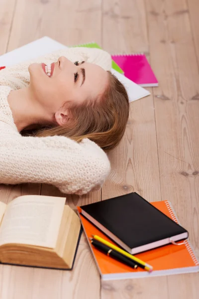 Vakker, hvit kvinne ligger på gulvet med bøker . – stockfoto