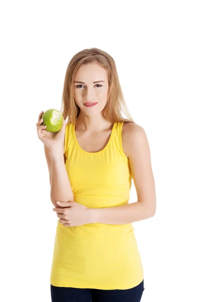 Beautiful causal caucasian woman holding fresh green apple with missing bite — Stock Photo, Image