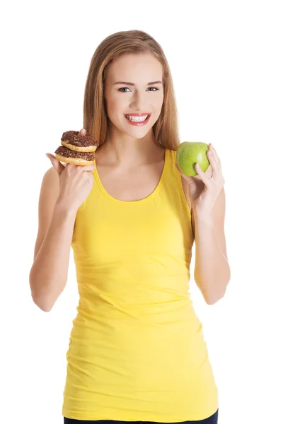 Hermosa mujer caucásica casual con donas y manzana . — Foto de Stock