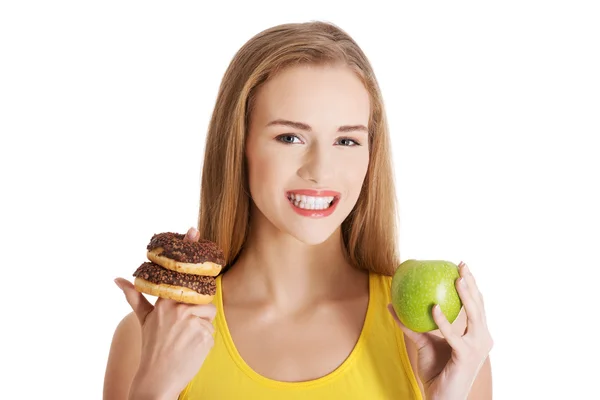 Mulher casual caucasiana bonita com donuts e maçã . — Fotografia de Stock