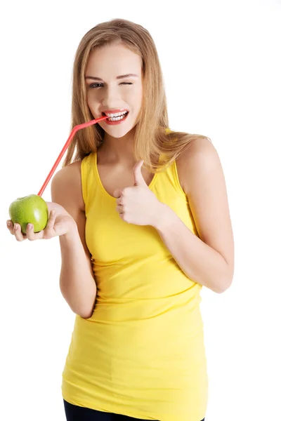 Mooie Kaukasische casual slanke vrouw sap drinken uit een appel — Stockfoto