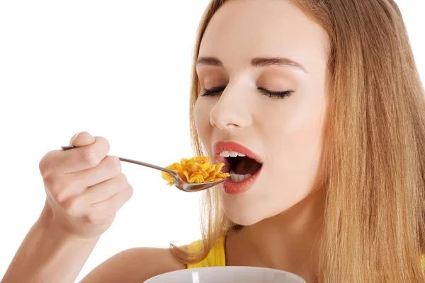 Mooie Kaukasische slanke vrouw eten cornflakes. — Stockfoto