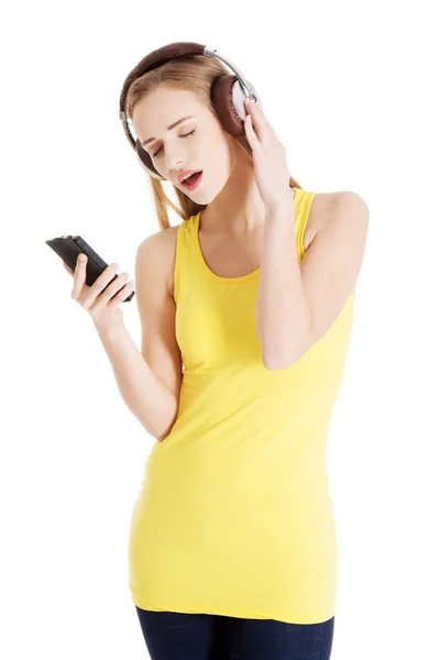 Bella donna casual in top giallo sta ascoltando musica . — Foto Stock