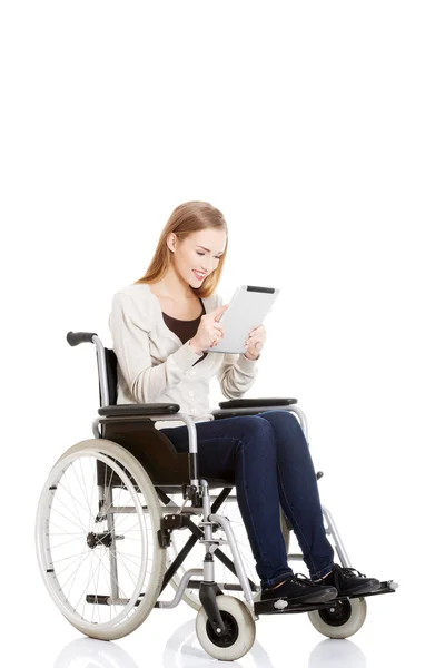 Beautiful casual woman sitting on w wheelchair with tablet. — Stock Photo, Image