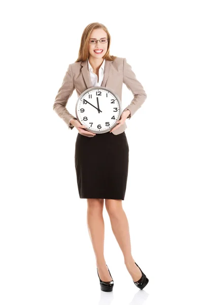 Young caucasian business woman holding clock. Stock Photo