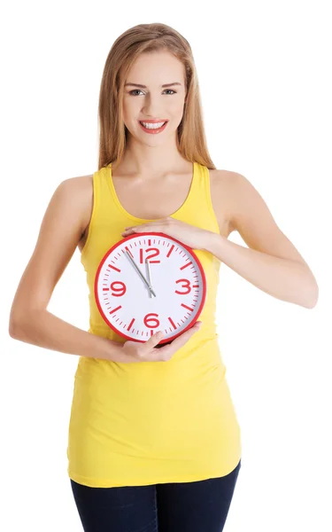 Beautiful caucasian casual woman holding red clock. Stock Image