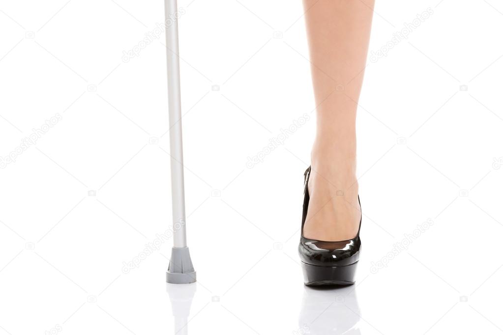 Woman's leg and a crutch. Disabled concept.