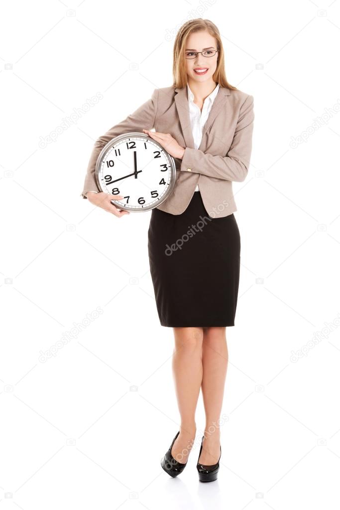Young caucasian business woman holding clock.