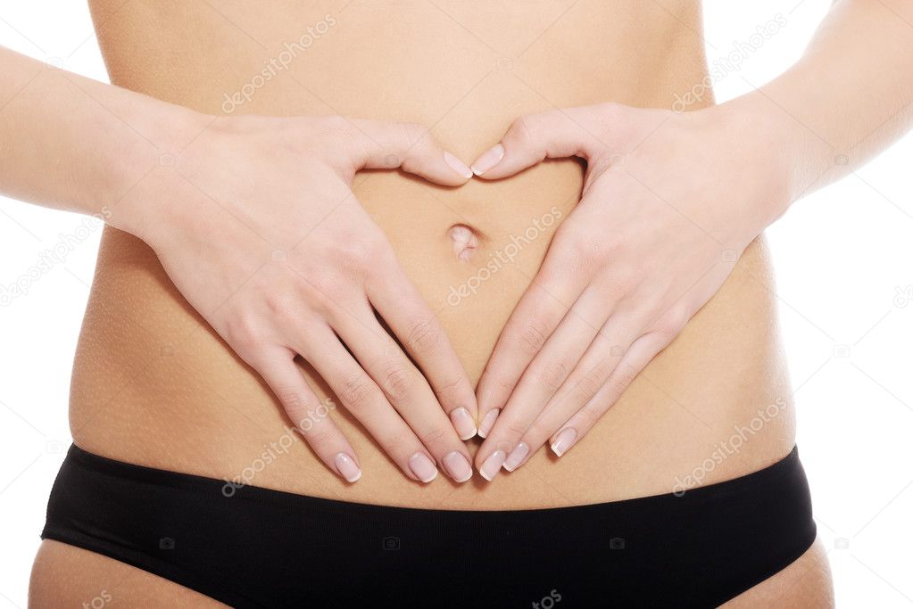 Woman is having heart shape made from hands on her belly.