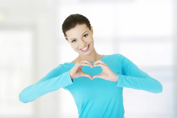 Attractiveyoung woman showing heart gesture — Stock Photo, Image