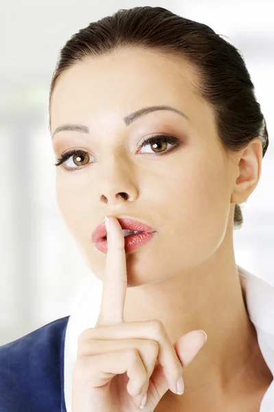 Portrait of attractive business woman with finger on lips — Stock Photo, Image