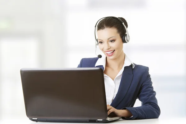 Beautiful young call-center assistant at the desk — Stock Photo, Image