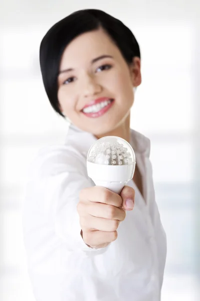 Mujer de negocios mostrando bombilla led —  Fotos de Stock