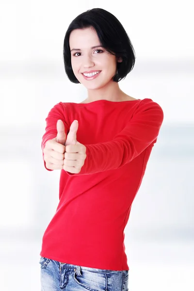 Mooie jonge vrouw gebaren duimen omhoog. — Stockfoto