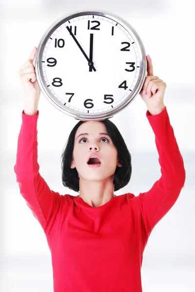 Femme choquée tenant horloge de bureau — Photo