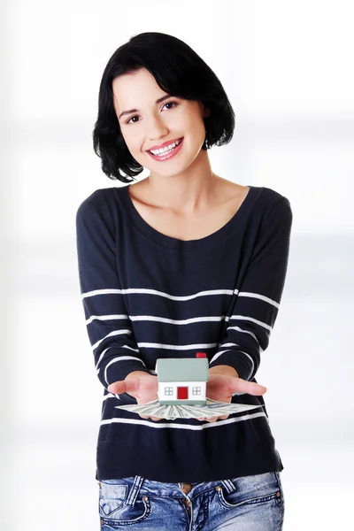 Woman holding US dollars bills and house model — Stock Photo, Image