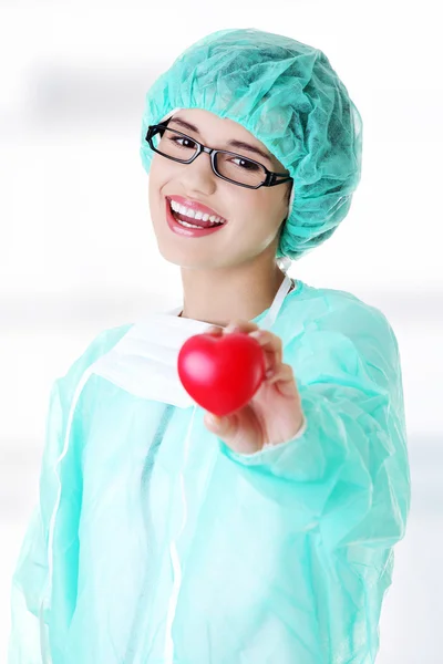 Médica sorridente ou enfermeira segurando o coração — Fotografia de Stock