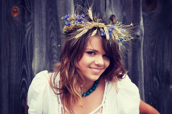 Beautiful young girl with grain wreath — Stock Photo, Image