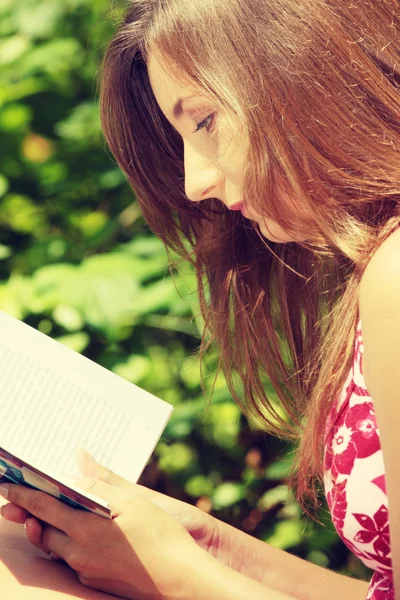 Reading woman laying in a park bench. — Stock Photo, Image