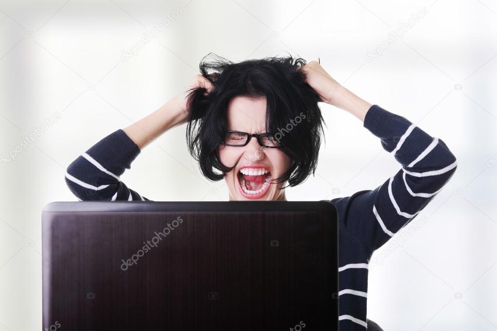 Frustrated woman working on laptop