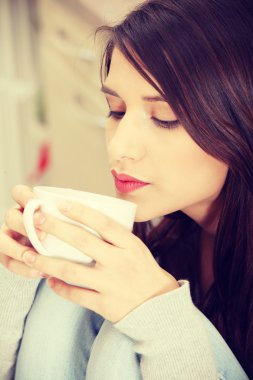 mutfakta kahve veya çay sahip genç bir kadın