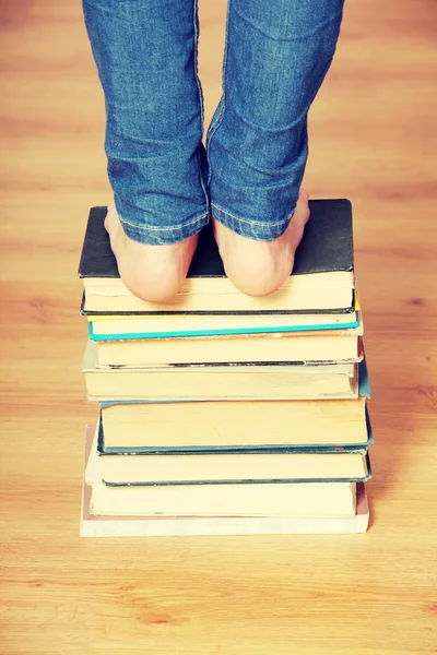 Menina de pé em livros — Fotografia de Stock