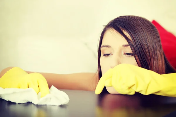 Mujer joven cansada limpiando muebles mesa — Foto de Stock