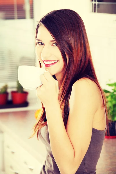 Hermosa mujer en la cocina bebiendo algo — Foto de Stock