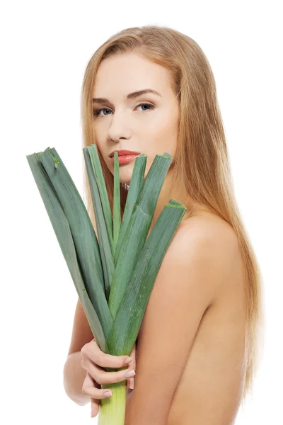 Vrouw bedrijf groene verse prei. — Stockfoto