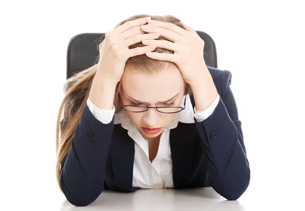 Besorgte, traurige Geschäftsfrau am Tisch. Stockbild