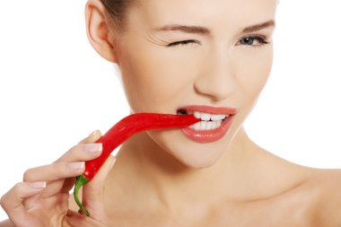 Woman with chili pepper in mouth. clipart