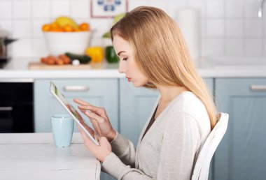 Tablet üzerinde çalışan güzel beyaz kadın.