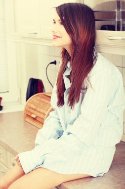 mutfak tezgahına oturmuş, genç, mutlu güzel kadın