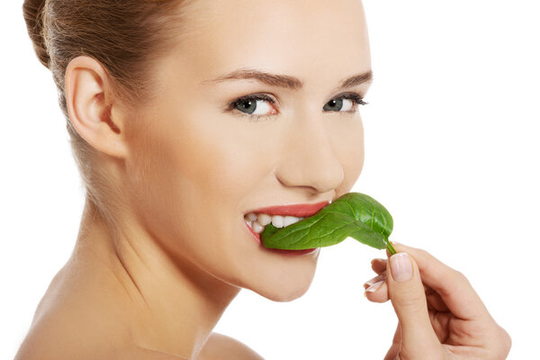 Beautiful caucasian topless woman with one green leaf.