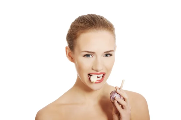 Nő a nyers fokhagymát a szájban. — Stock Fotó