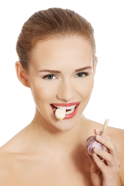 Woman with raw garlic in mouth. — Stock Photo, Image