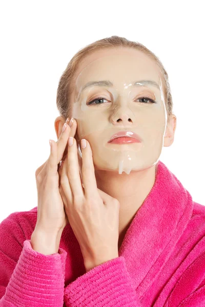 Mujer en albornoz rosa con máscara de colágeno . — Foto de Stock