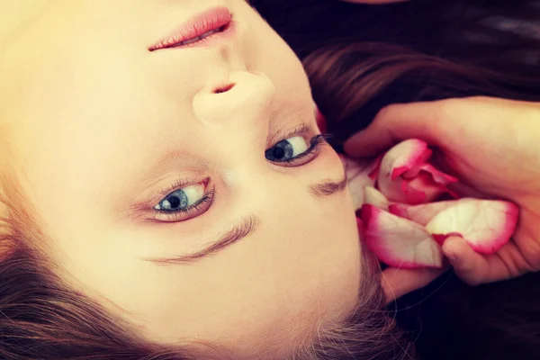 Cara de mulher e pétalas de rosa — Fotografia de Stock