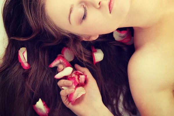 Volto femminile e petali di rosa — Foto Stock