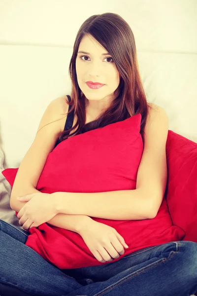 Young happy woman sitting on sofa — Stock Photo, Image