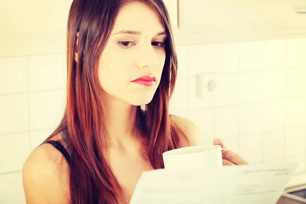 Woman in the kitchen with bill — Stock Photo, Image