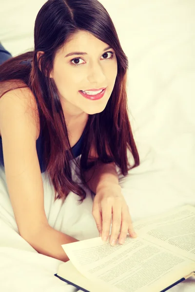 Vrouw lezen van een boek op het bed — Stockfoto