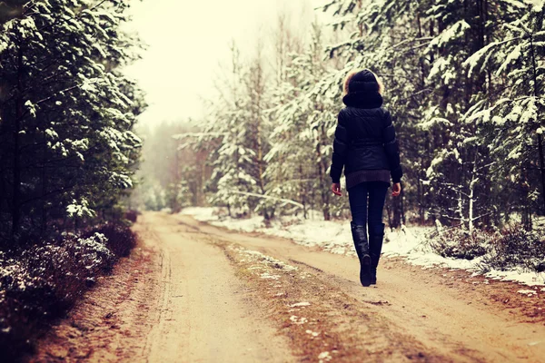 Žena kráčí lesem v zimě — Stock fotografie