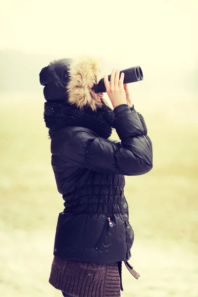 Žena drží lorgnette v chladném zimním dni. — Stock fotografie